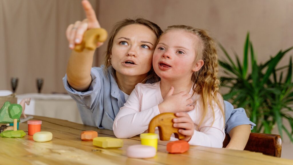 young-girl-with-down-syndrome-looking-up-at-what support-lady-is pointing-at
