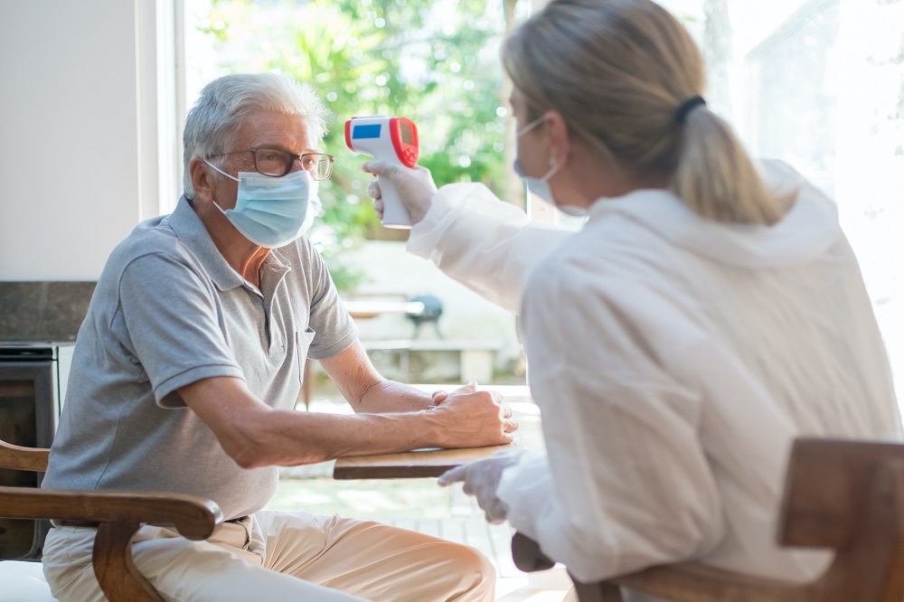 lady-wearing-clinical-mask-checking-temperature-of-elderly-man-wearing-clinical-mask