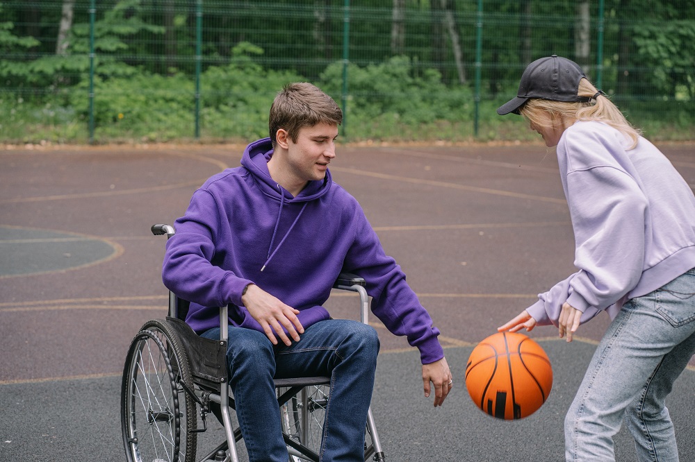 lady-playing-basketball-with-young-man-on-wheelchair